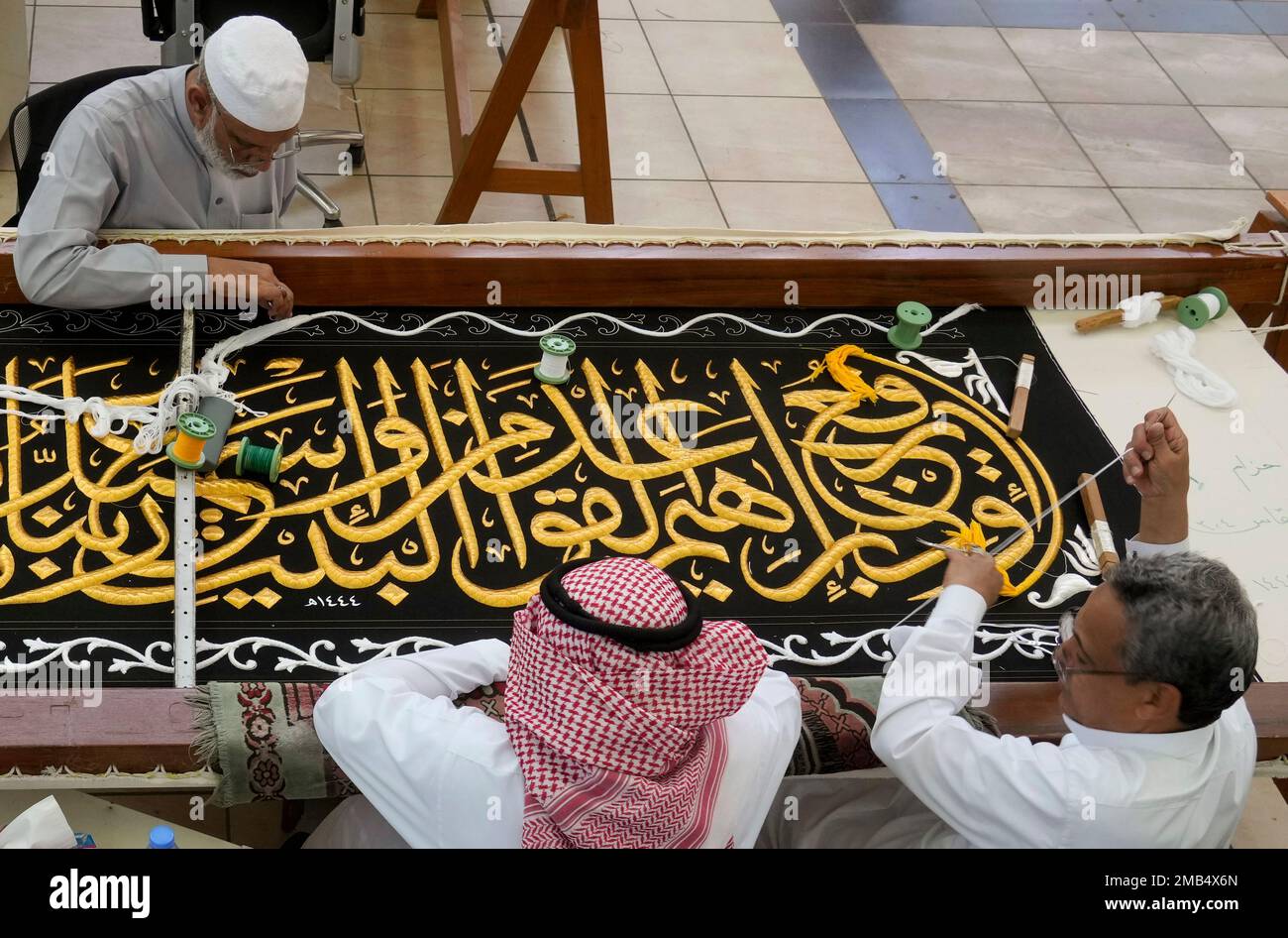 Saudi workers embroider Islamic calligraphy using either pure silver