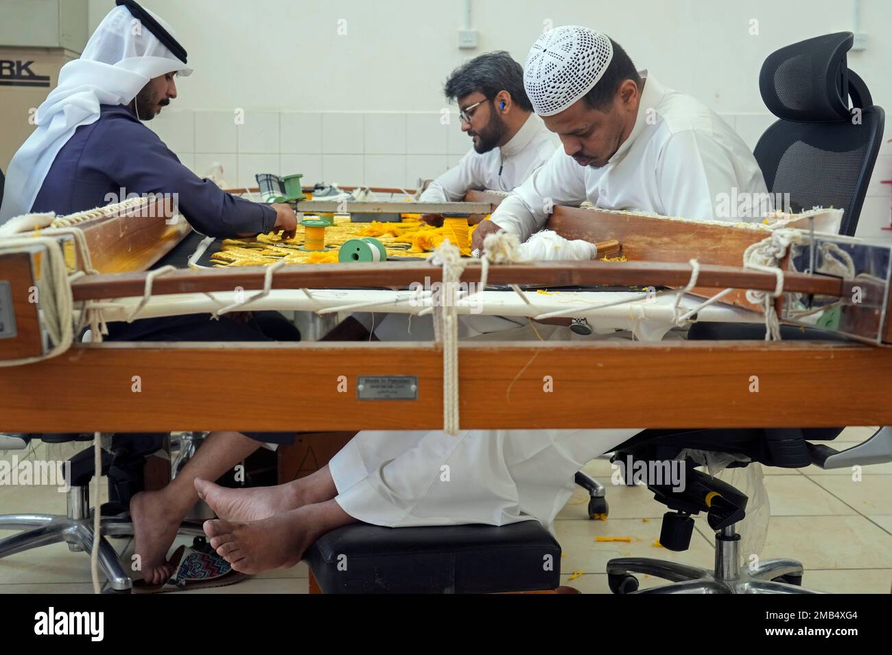 Saudi workers embroider Islamic calligraphy, using either pure silver