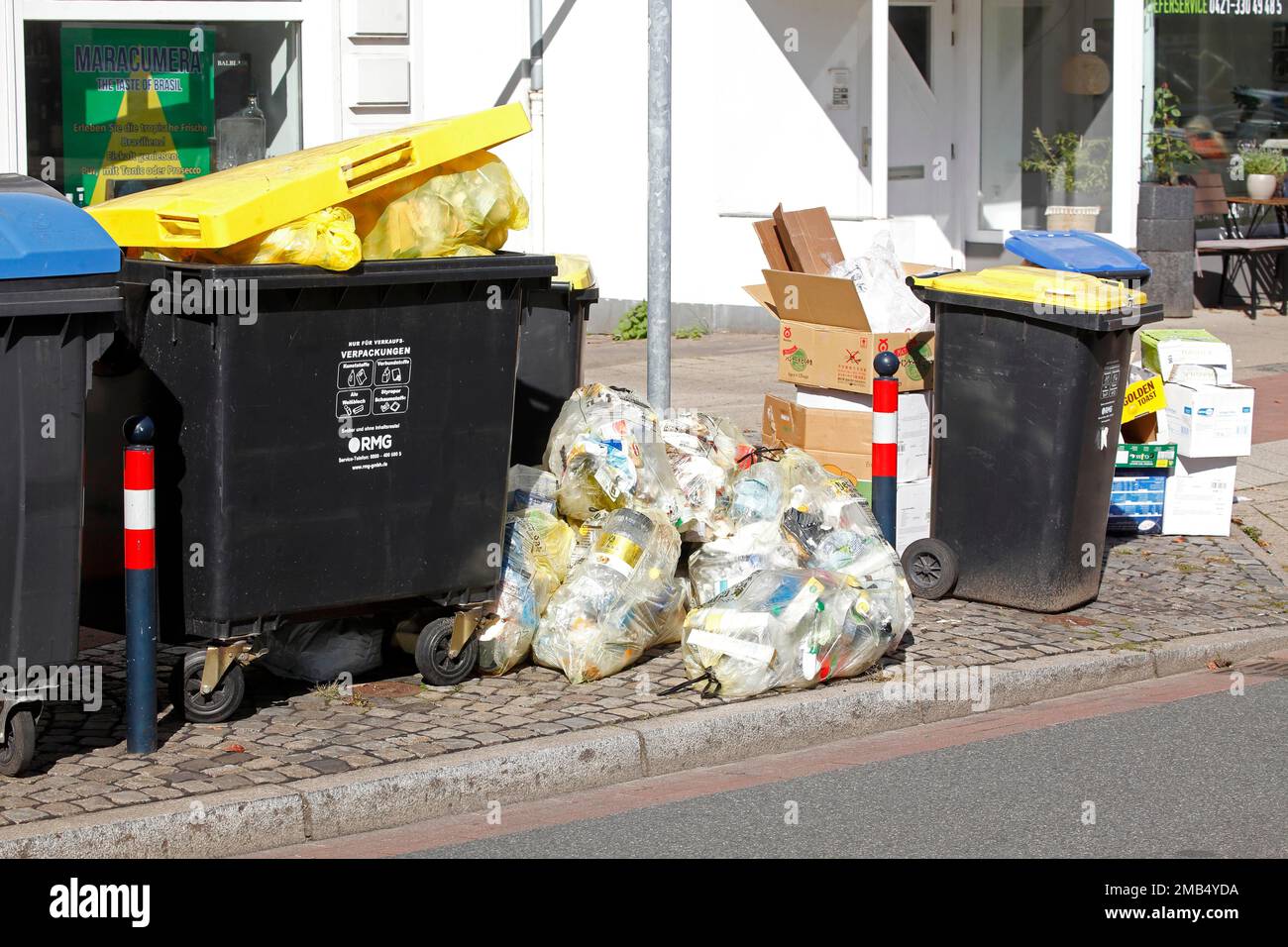 Yellow bags and yellow bins for plastic waste standing on the street, waste separation, Germany