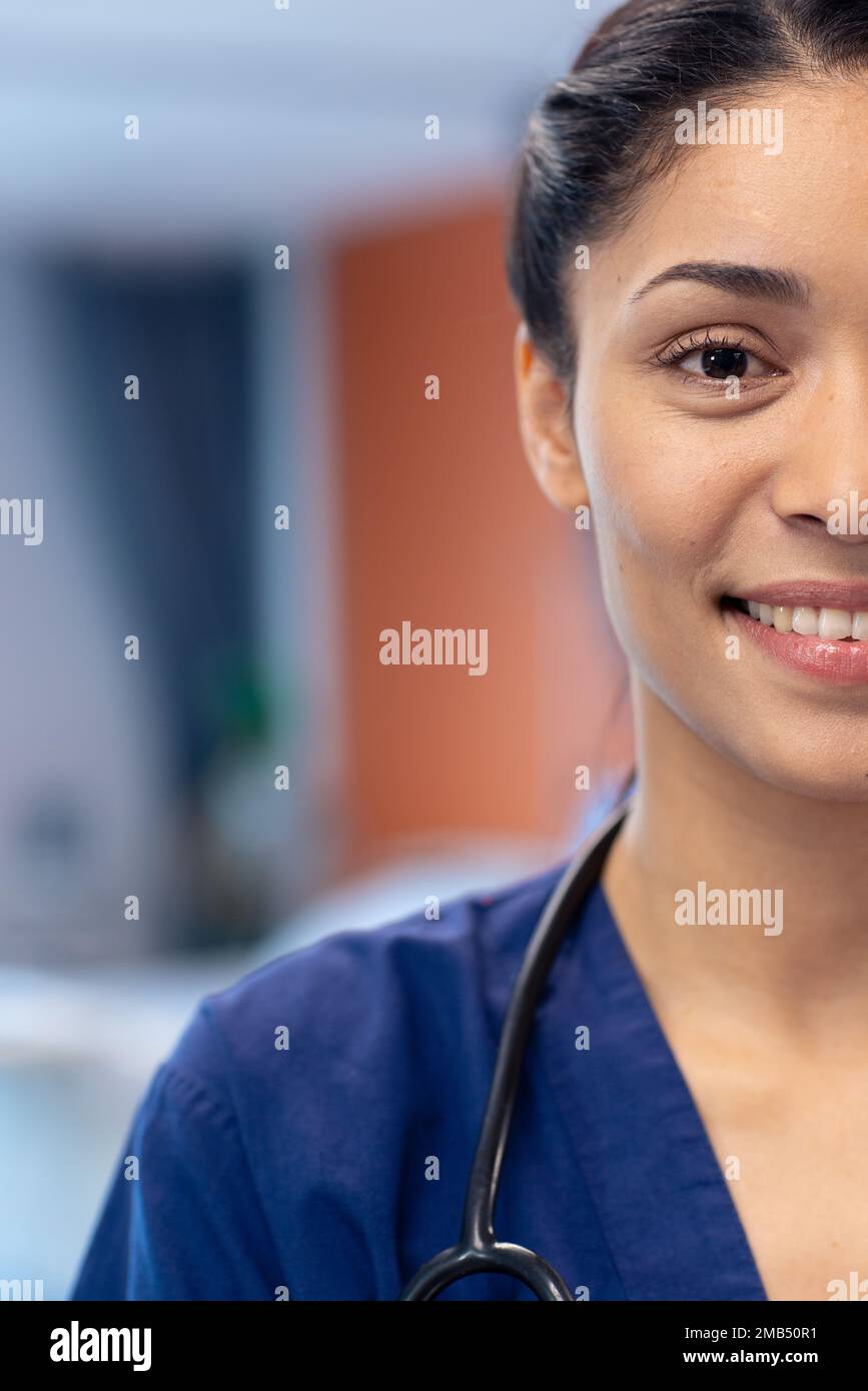 Vertical half face portrait of smiling biracial female doctor in hospital ward, copy space Stock Photo