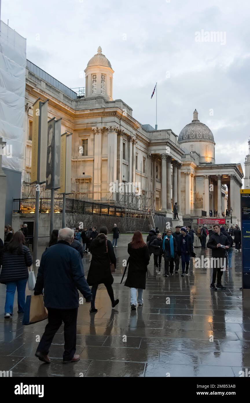 People walking by the National Gallery illuminated on Trafalgar Square at sundown Stock Photo