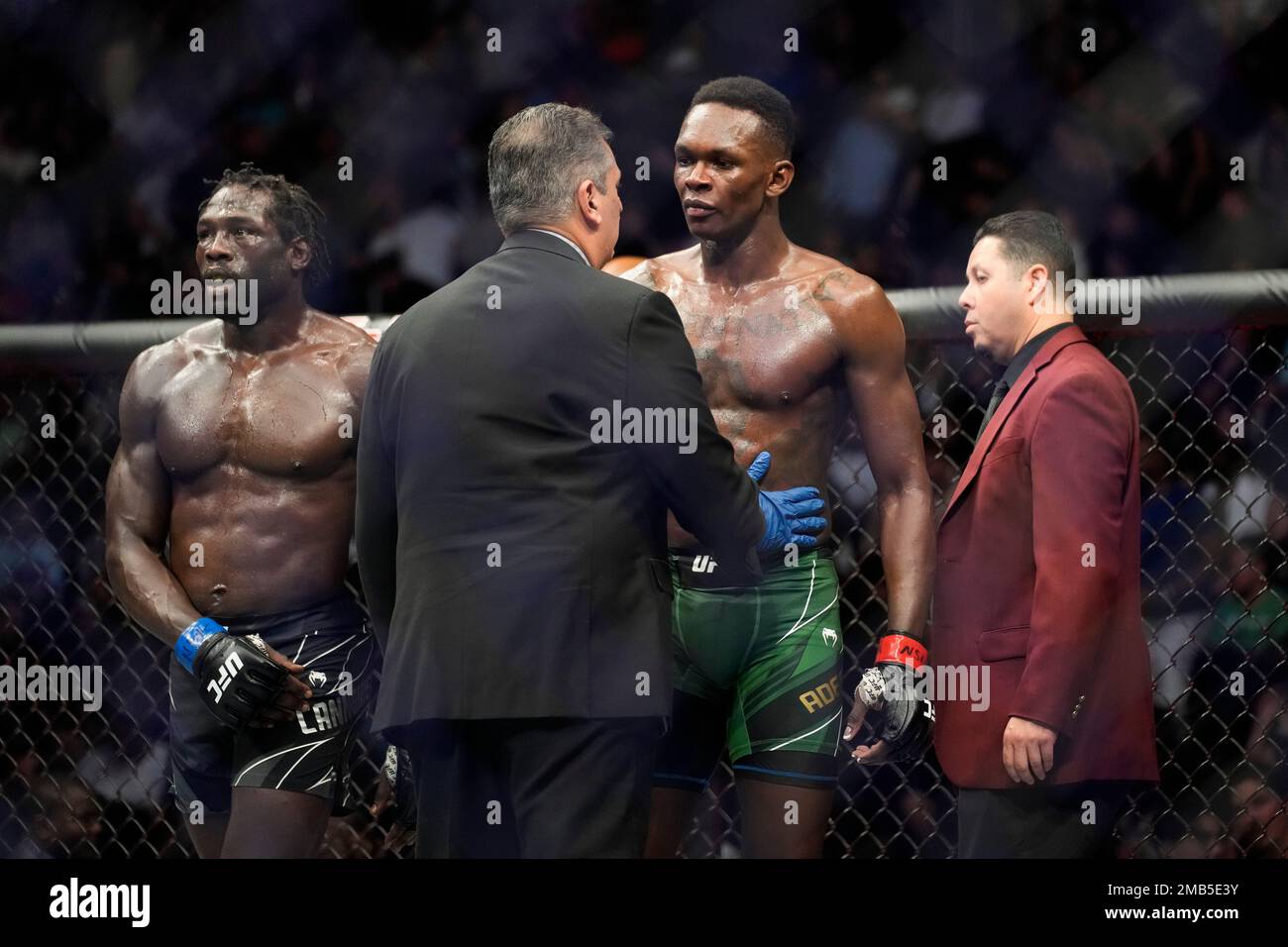 Israel Adesanya, center right, is checked out after he winning a middleweight title bout against Jared Cannonier, left, during the UFC 276 mixed martial arts event Saturday, July 2, 2022, in Las