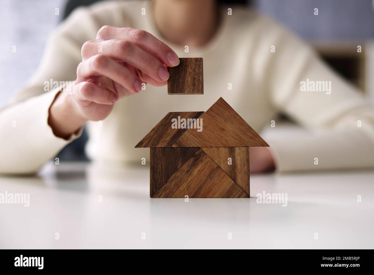 Woman Building House With Wooden Tangram Puzzle Stock Photo