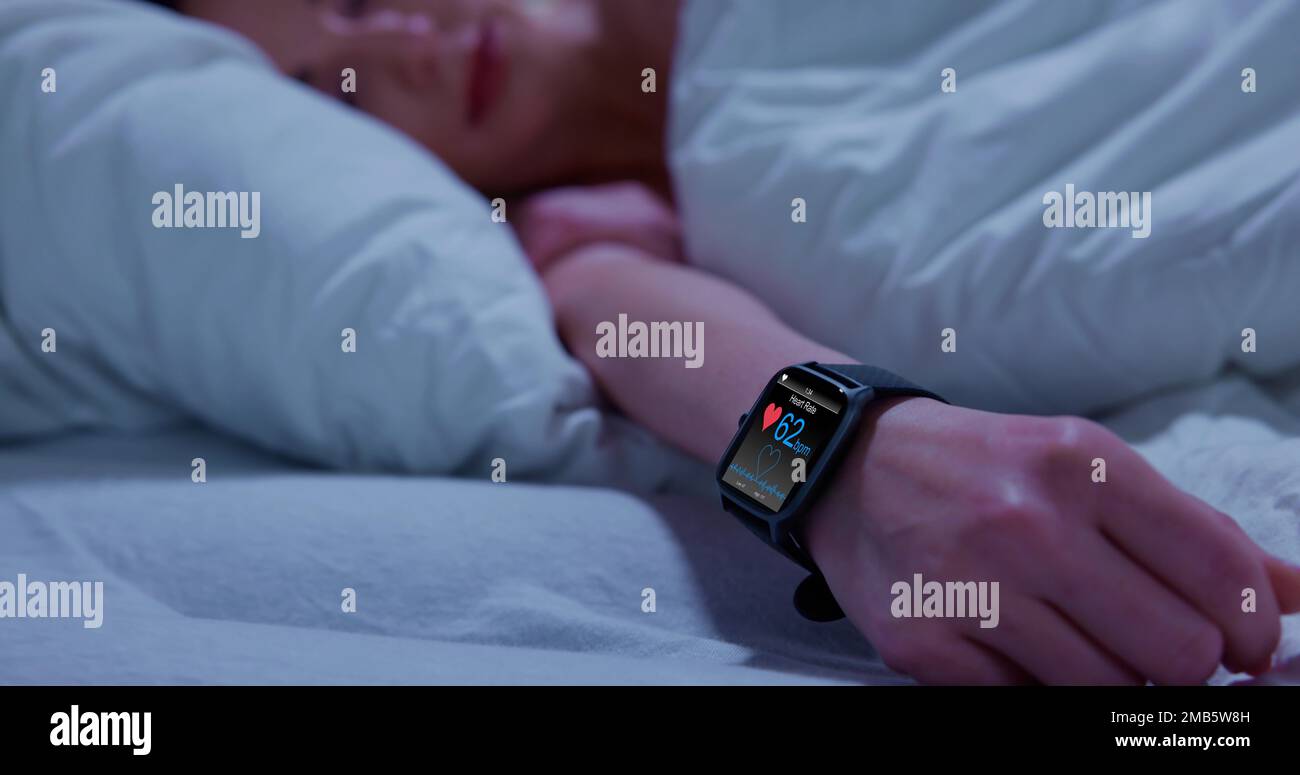 Wearable sleep tracking heart rate monitor smartwatch in bed stock