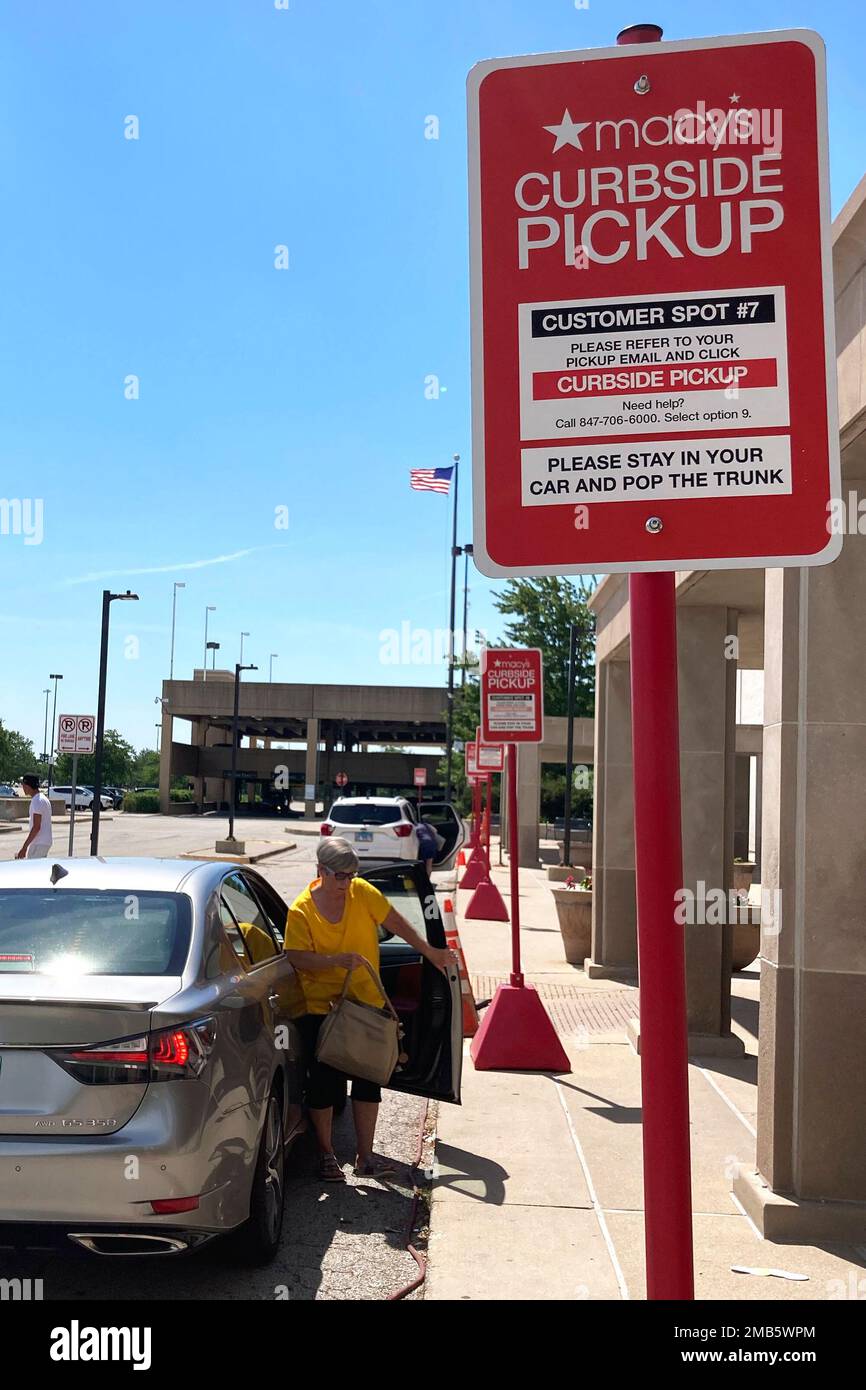 Curbside pickup signs are seen in front of a department store in