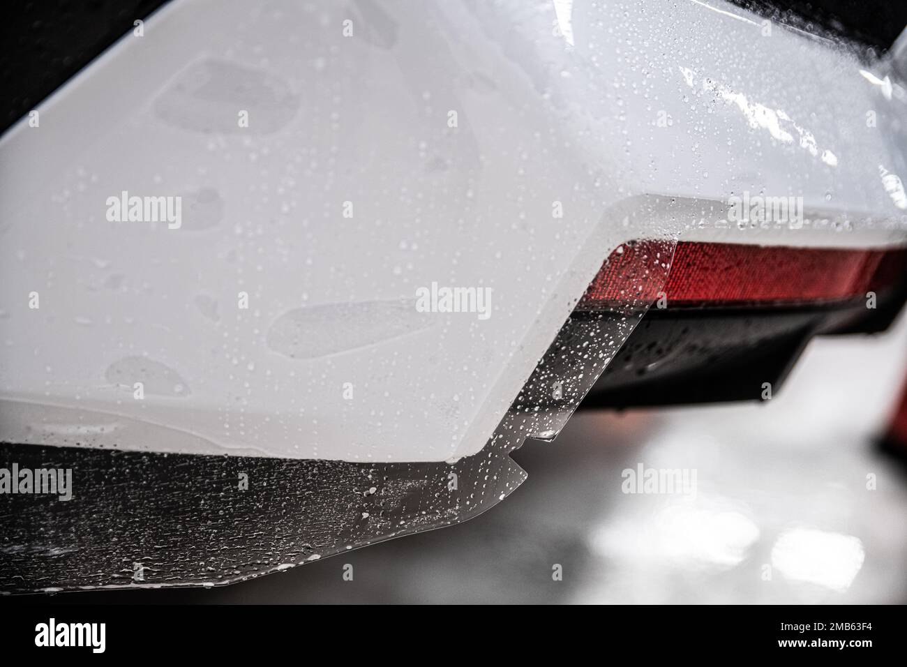 Colorless protective film covering the paintwork of a white car Stock Photo