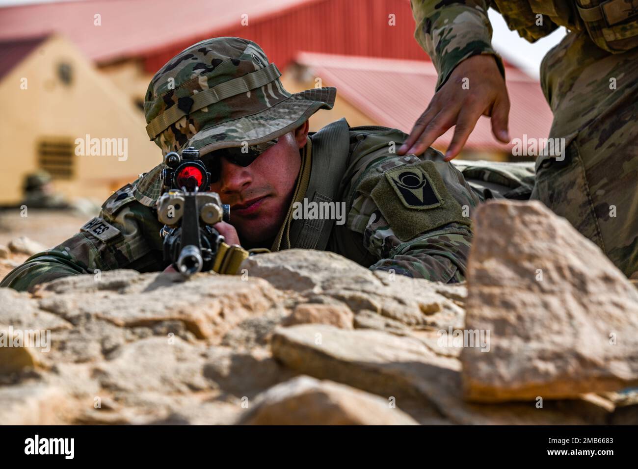 A U.S. Soldier assigned to Task Force Hurricane from the 1st Battalion, 124th Infantry Regiment, holds security during a platoon immersion in Al-Kharj, Kingdom of Saudi Arabia, June 12, 2022. The immersion was a training event meant to build interoperability between the U.S Army and Royal Saudi Land Force at the platoon level while enhancing both U.S. and partner nation skillsets. Stock Photo