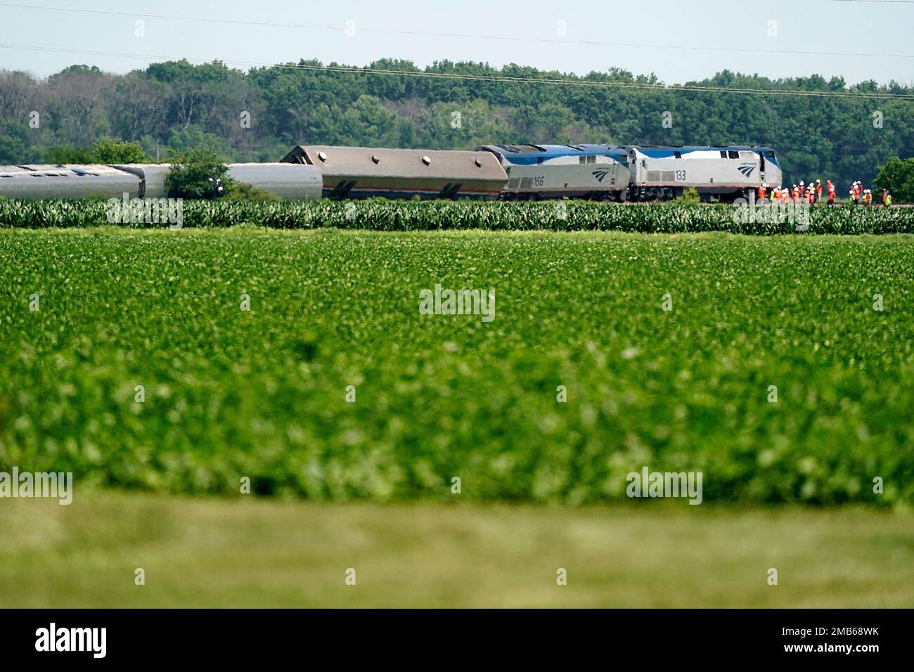 Workers gather at the front of a derailed Amtrak train Tuesday, June 28