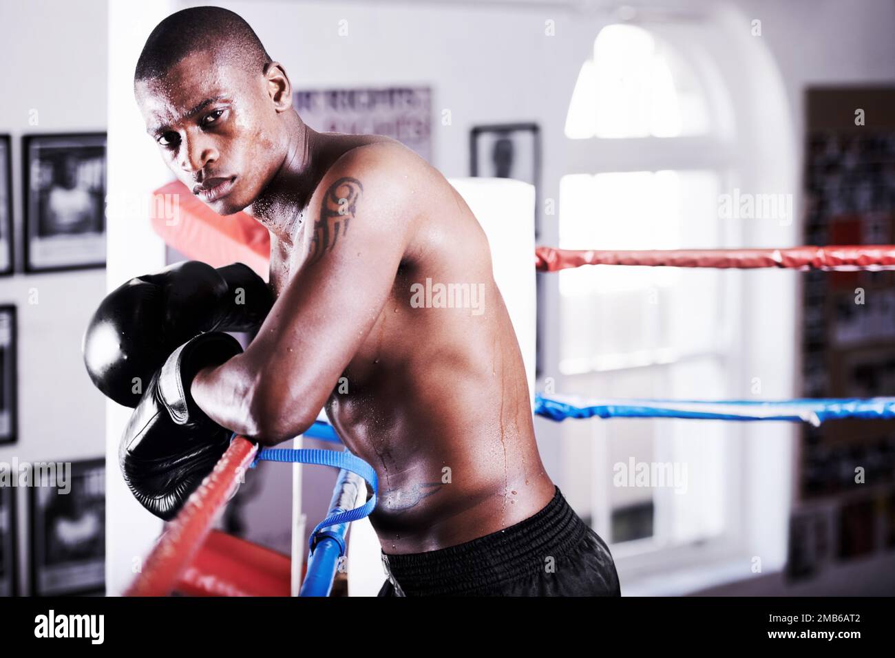 One day the title will be his. A determined boxer leaning on the ropes alongside copyspace. Stock Photo