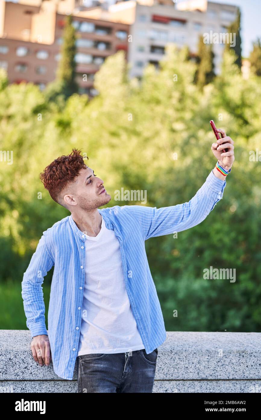Young gay man with lgtb bracelet taking a selfie. Concept of LGBT, relationship and equal rights. Stock Photo