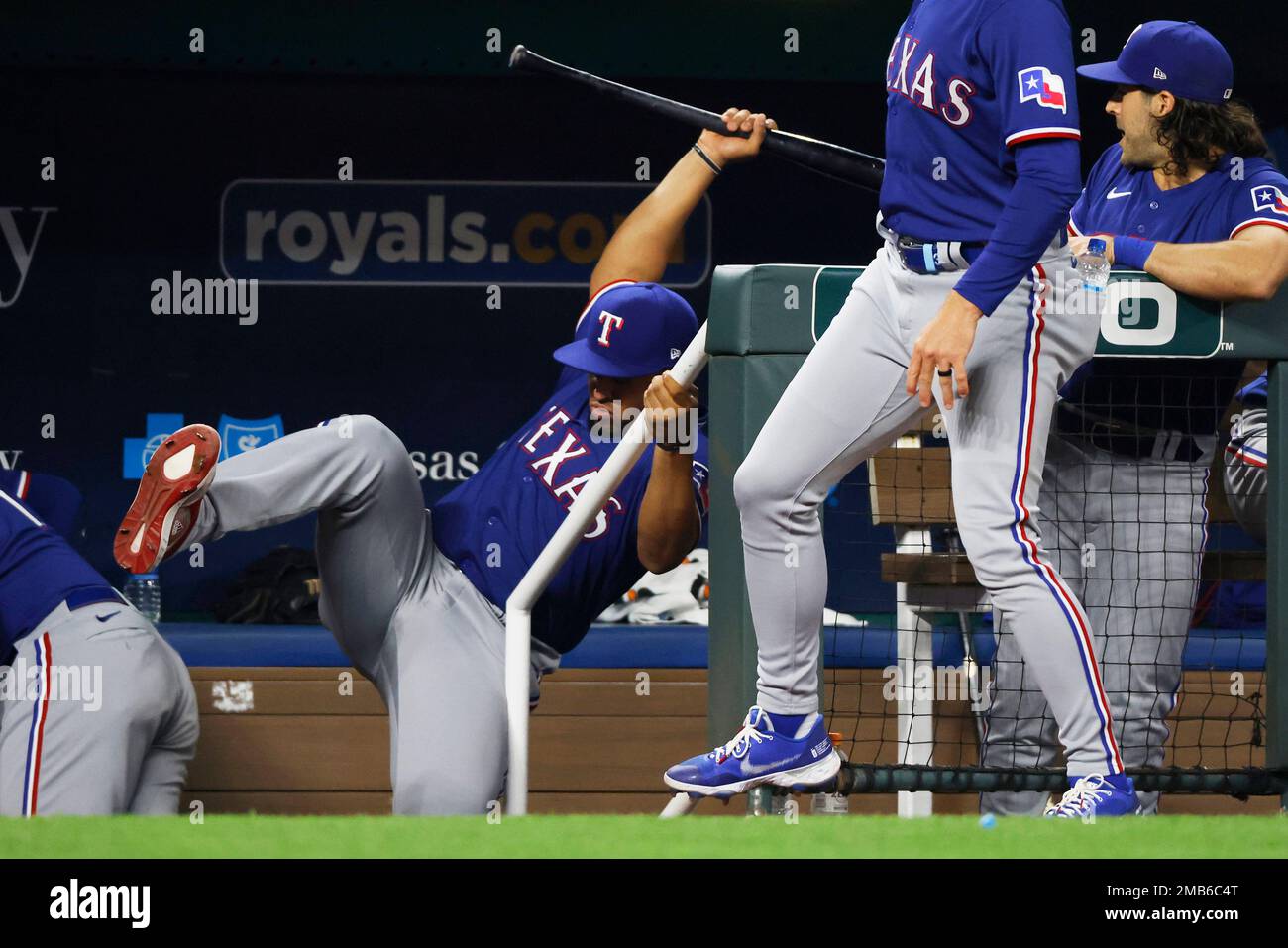 Texas Rangers' Meibrys Viloria, left, catches a bat in the dugout after