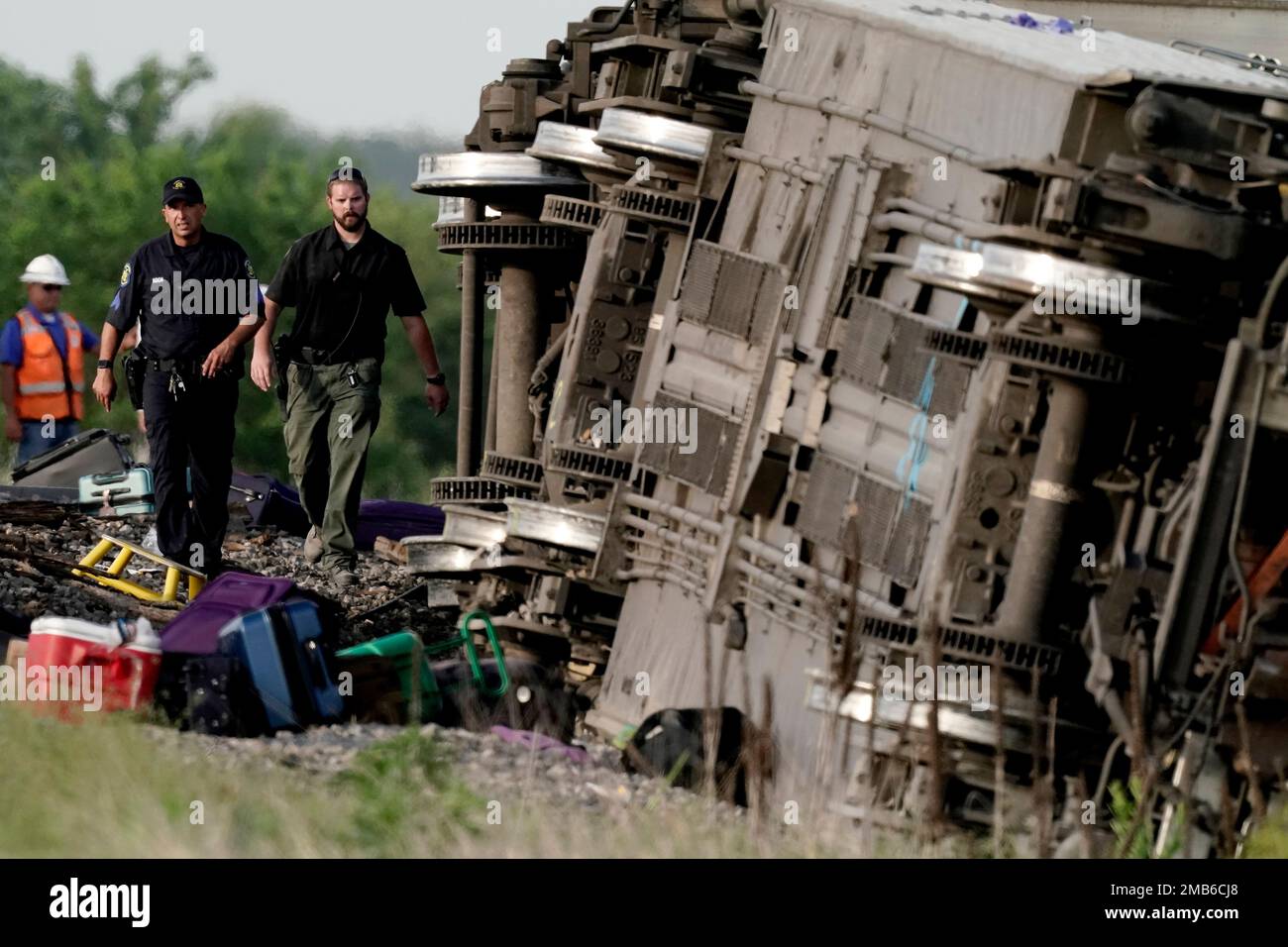 Law enforcement personnel inspect the scene of an Amtrak train which