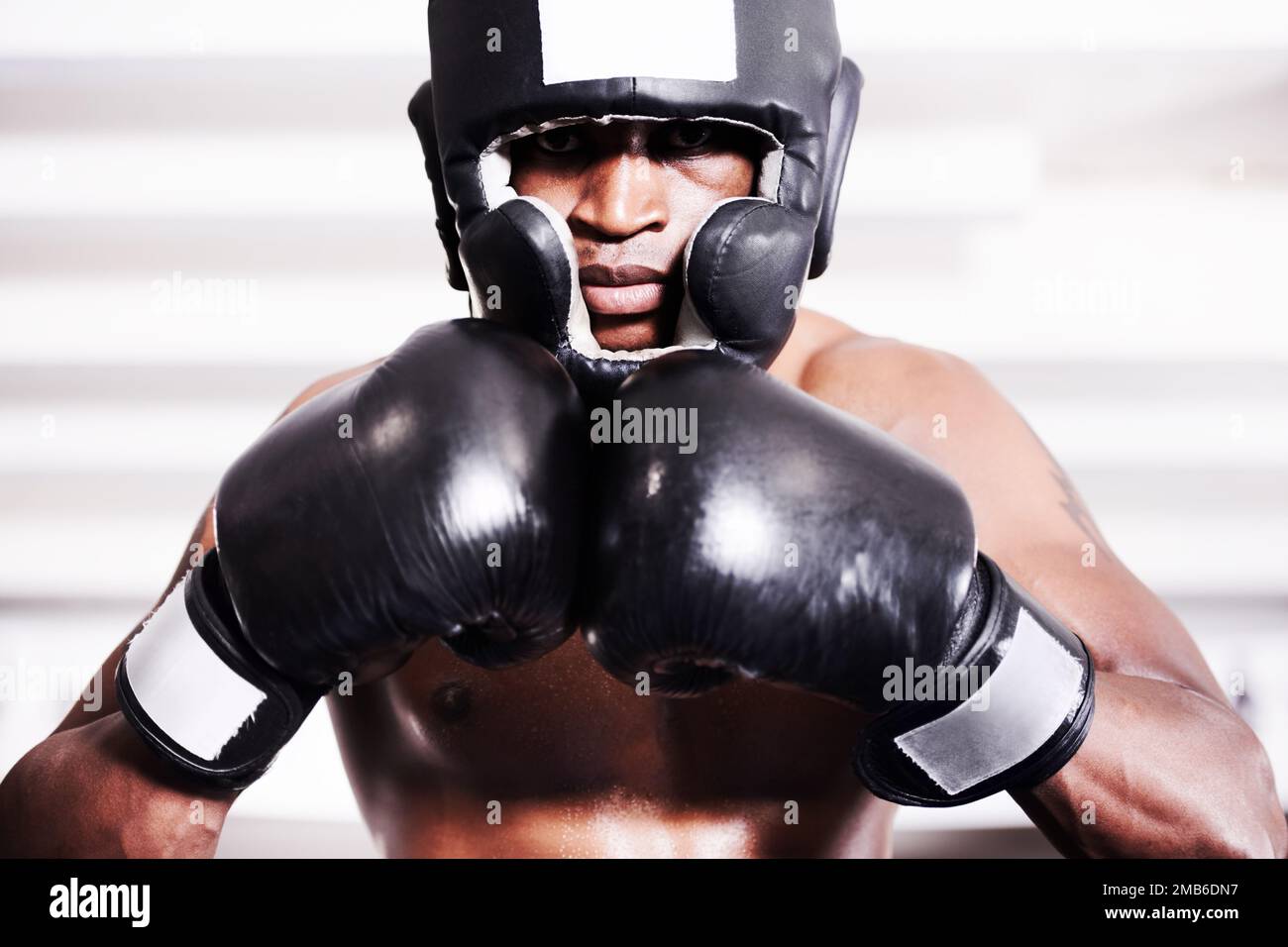 Lets go. An african american boxer wearing protective gear standing in the ring. Stock Photo
