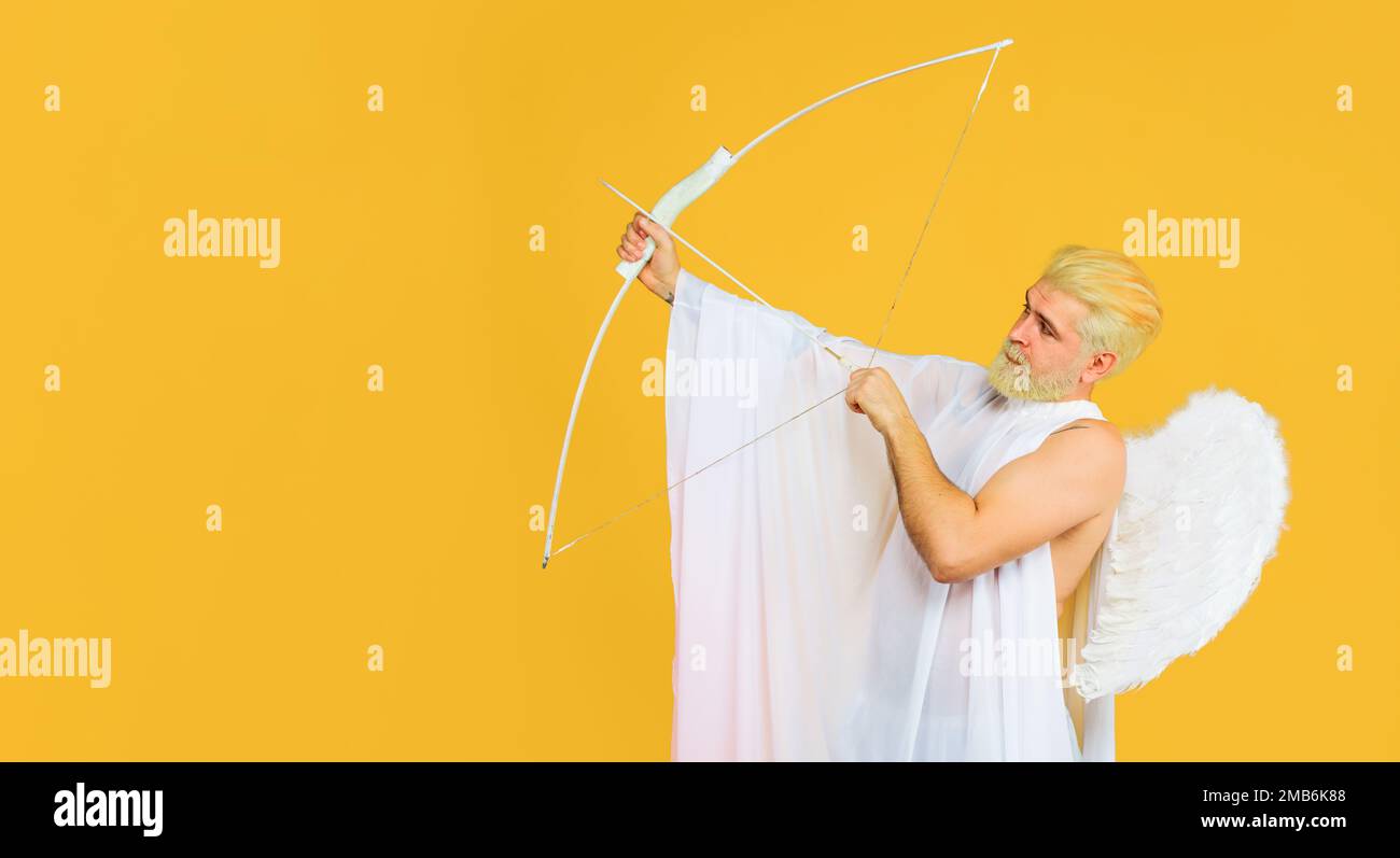 Valentines cupid angel throws arrow of love. Male angel in angelic feather wings. Stock Photo