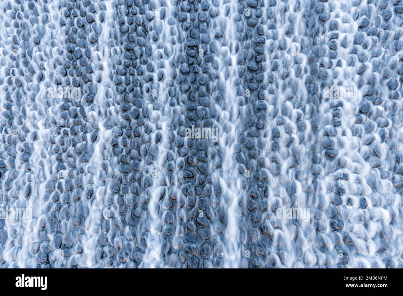 jets of water flowing down artificial stones. Artificial waterfall. Stock Photo