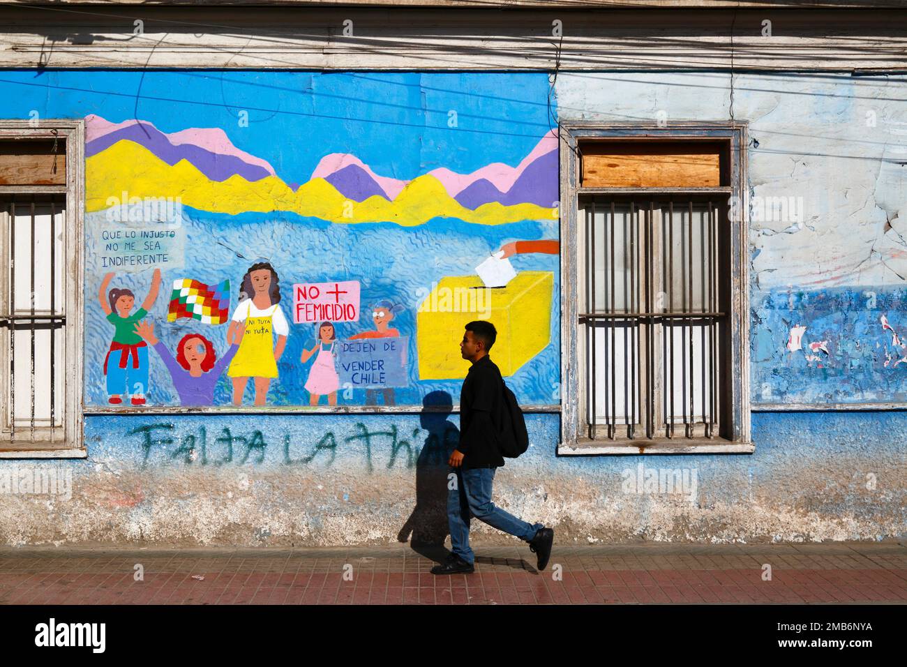 Man walking past mural on wall of school protesting against violence against women and demanding equal rights for women, Copiapo, Region III, Chile Stock Photo
