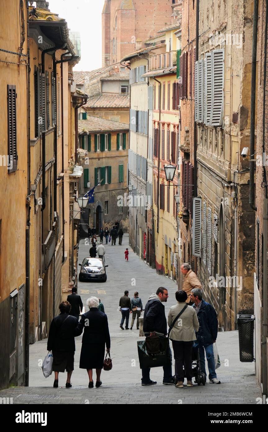Narrow shopping street with ancient tall buildings, Siena, Tuscany