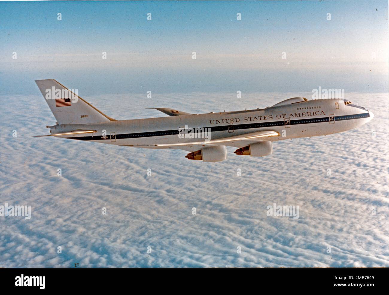 An E4B (NEACP) National Emergency Airborne Command Post, based at 595th Command and Control Group at Offutt Air Force Base, Nebraska, in flight over clouds on March 26, 1985. The E-4B is a militarized version of the Boeing 747-200, a four-engine, swept-wing, long-range high-altitude airplane capable of refueling in flight. In case of national emergency or destruction of ground command and control centers, the aircraft provides a highly survivable command, control and communications center to direct United States forces, execute emergency war orders and coordinate actions by civil authorities. Stock Photo