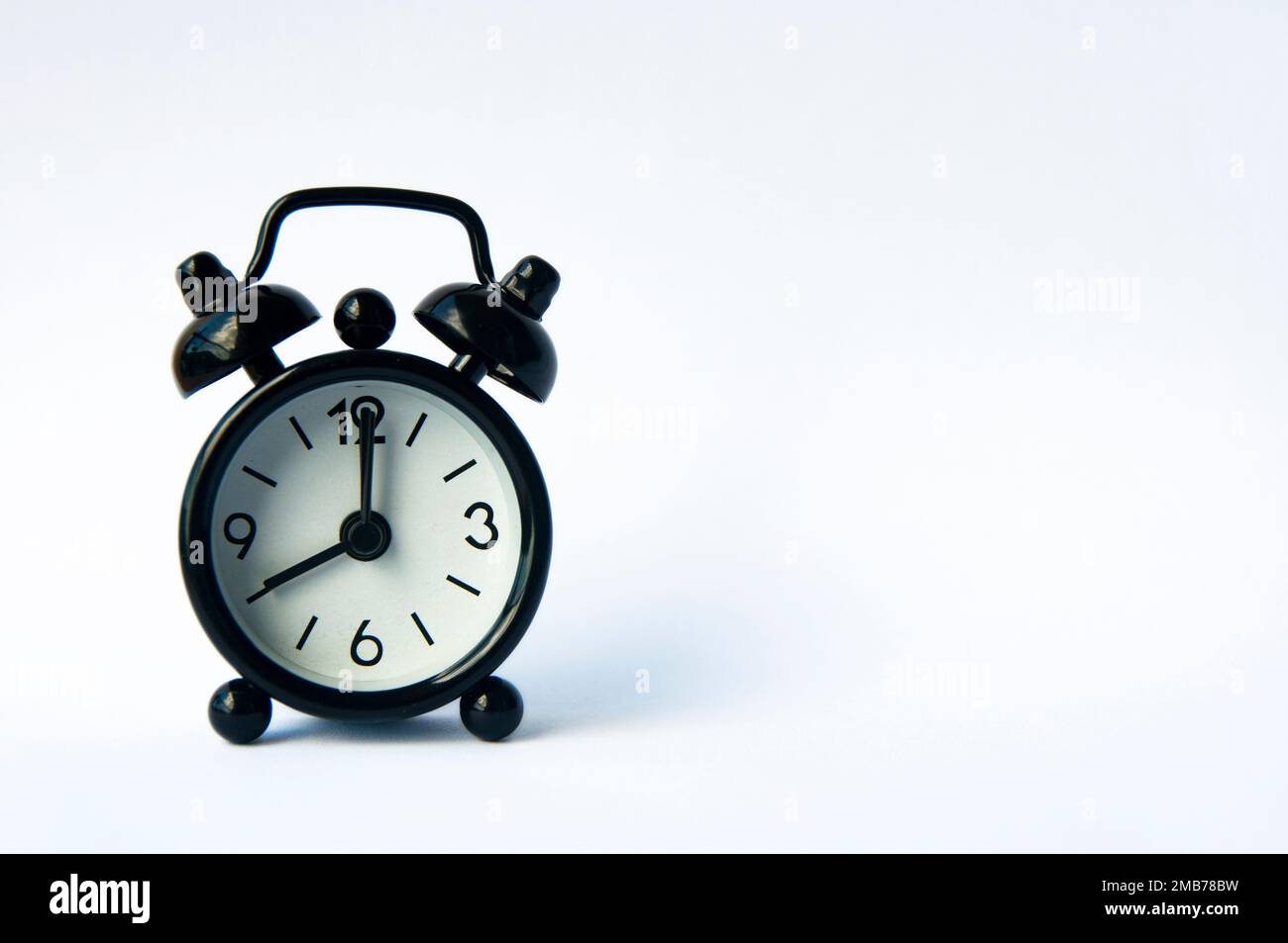 Black alarm clock on nature background with copy space Stock Photo