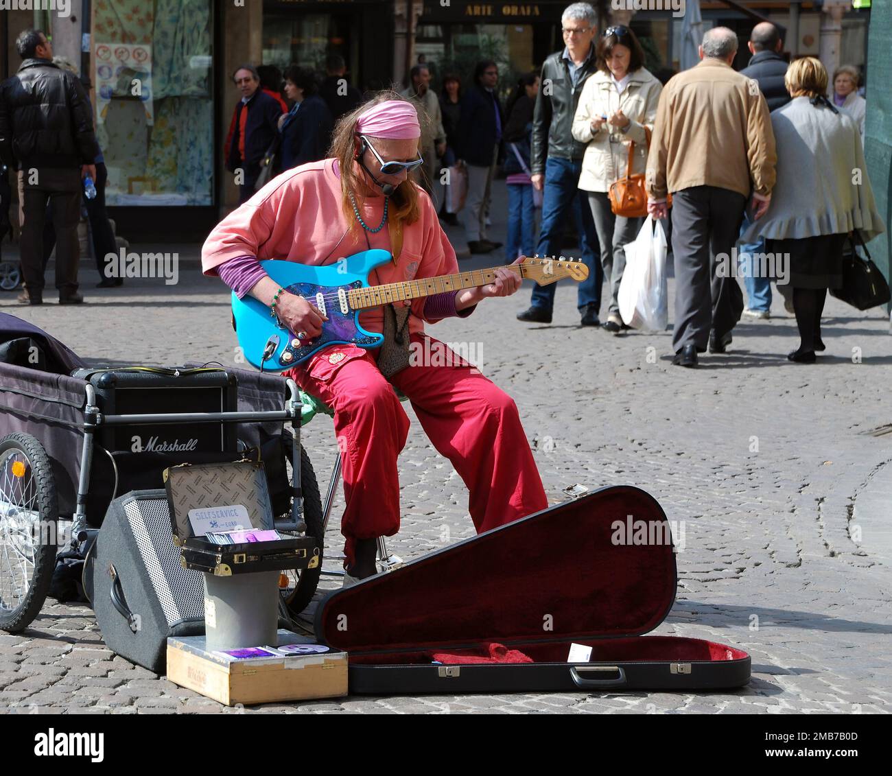 Street performer playing rock music with an electric guitar in the