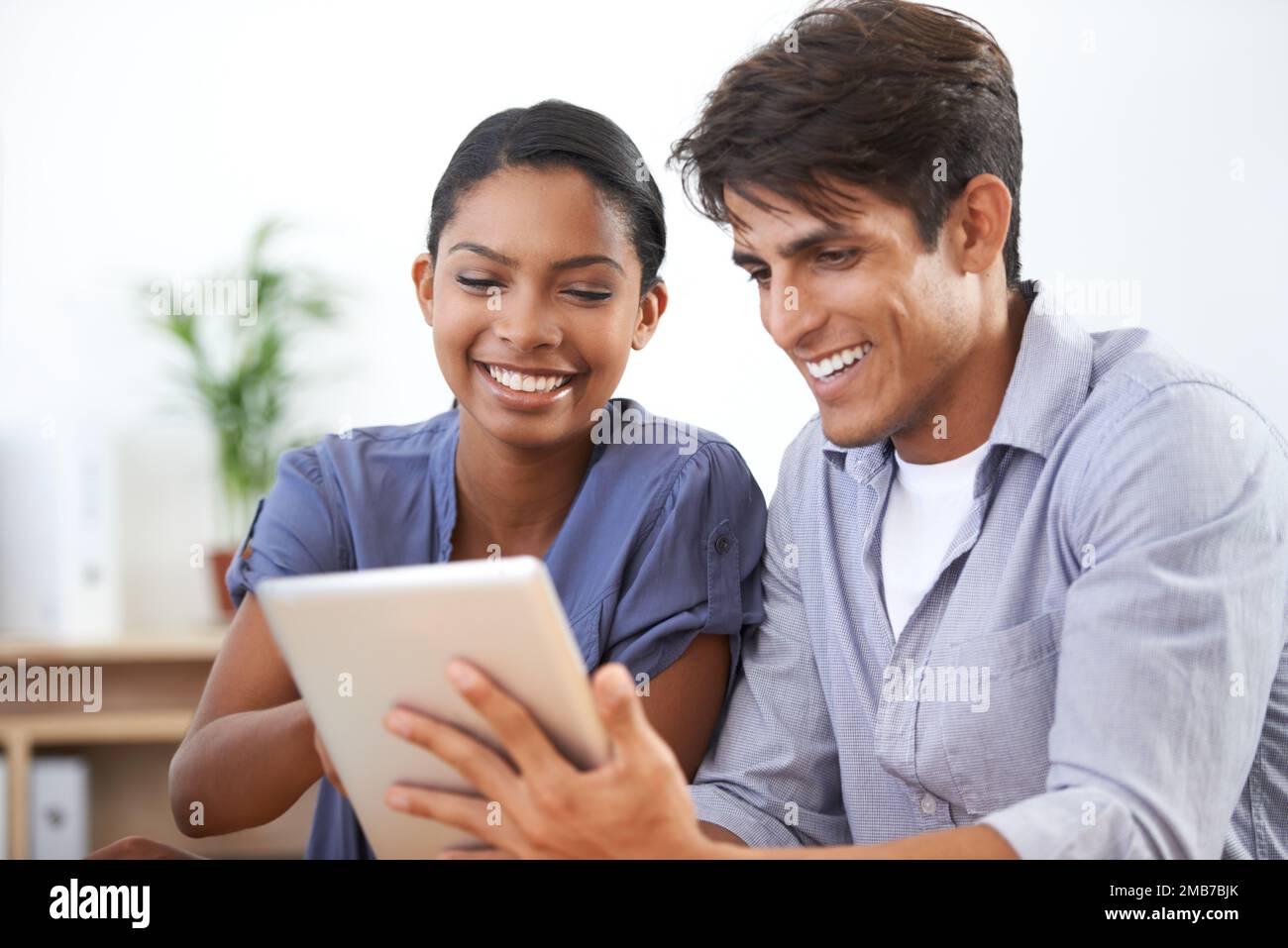 Check this out. two young colleagues using a digital tablet. Stock Photo