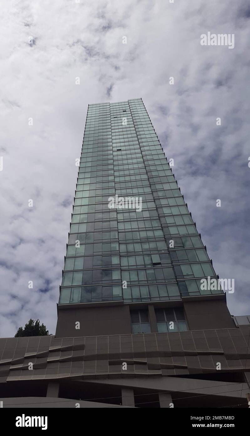 A low angle shot of of a skyscraper with cloudy sky in the background ...