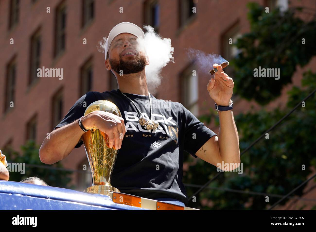 Stephen Curry smokes a cigar during the Golden State Warriors NBA  championship parade in San Francisco, Monday, June 20, 2022. (AP Photo/Eric  Risberg Stock Photo