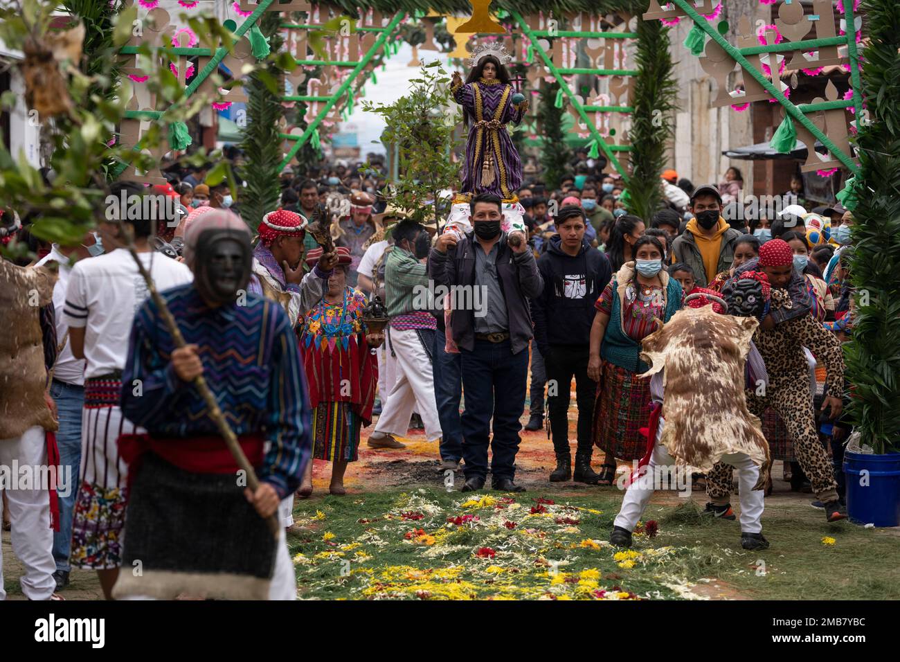 Faithfull carry a statue of baby Jesus as Indigenous dancers perform