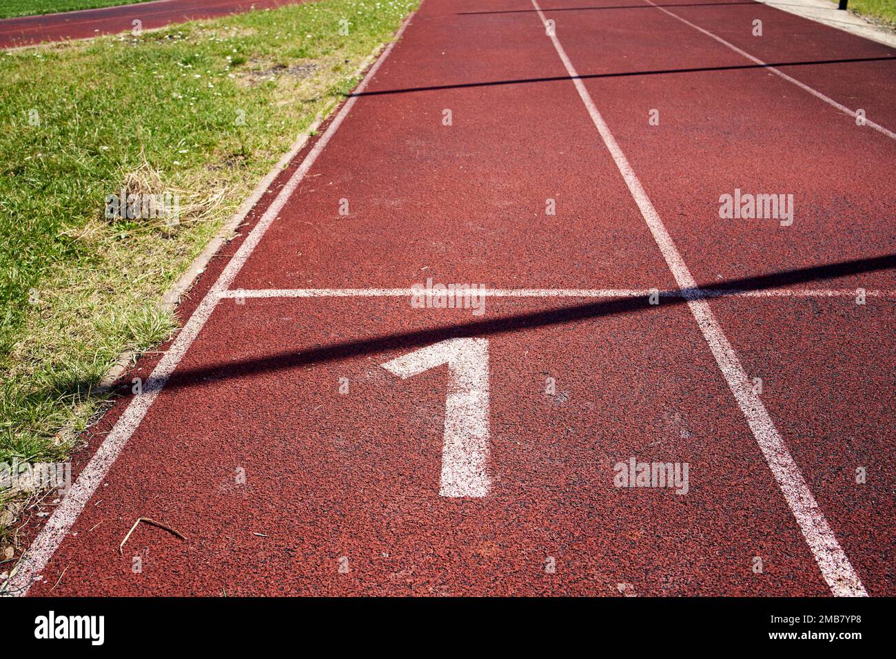 Red running lane with number one on it Stock Photo Alamy