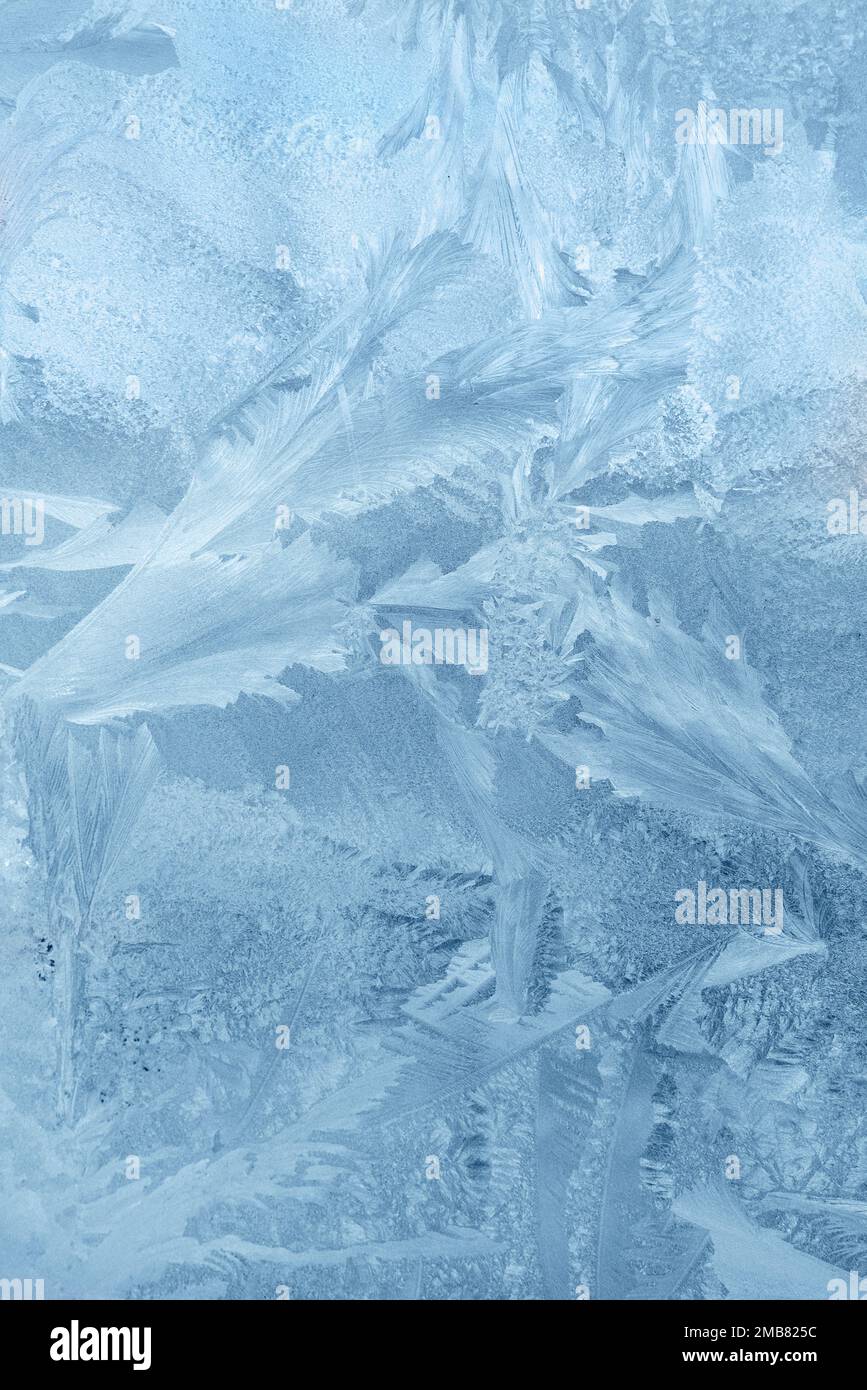 Frozen window, frost drawing on glass in cold winter. Ice texture Stock Photo