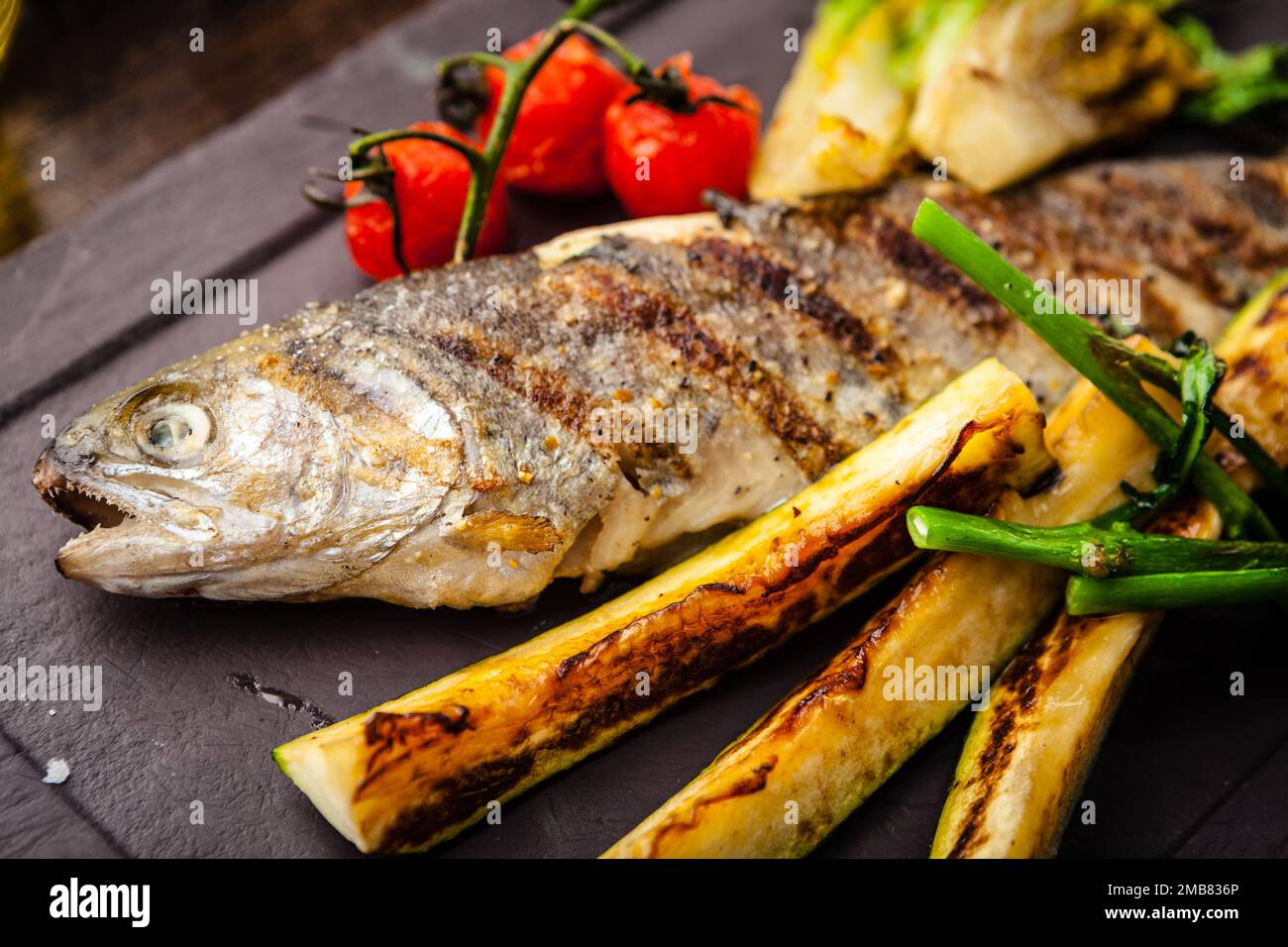 Rainbow trout grilled. Vegetables, white wine sauce. Delicious healthy traditional food closeup served for lunch in modern gourmet cuisine restaurant Stock Photo