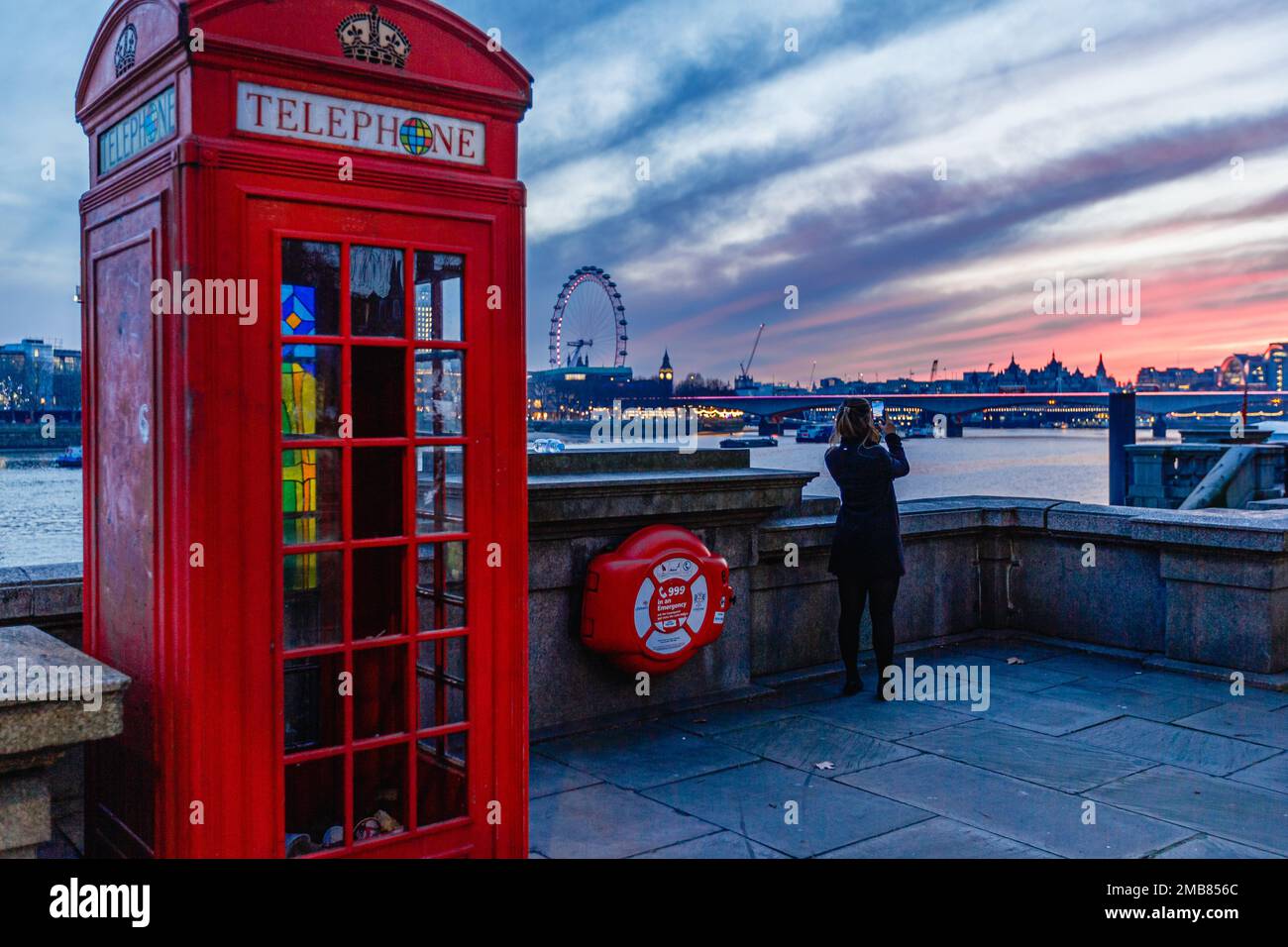 A tourist takes a photograph of the beautiful sunset over London. Stock Photo