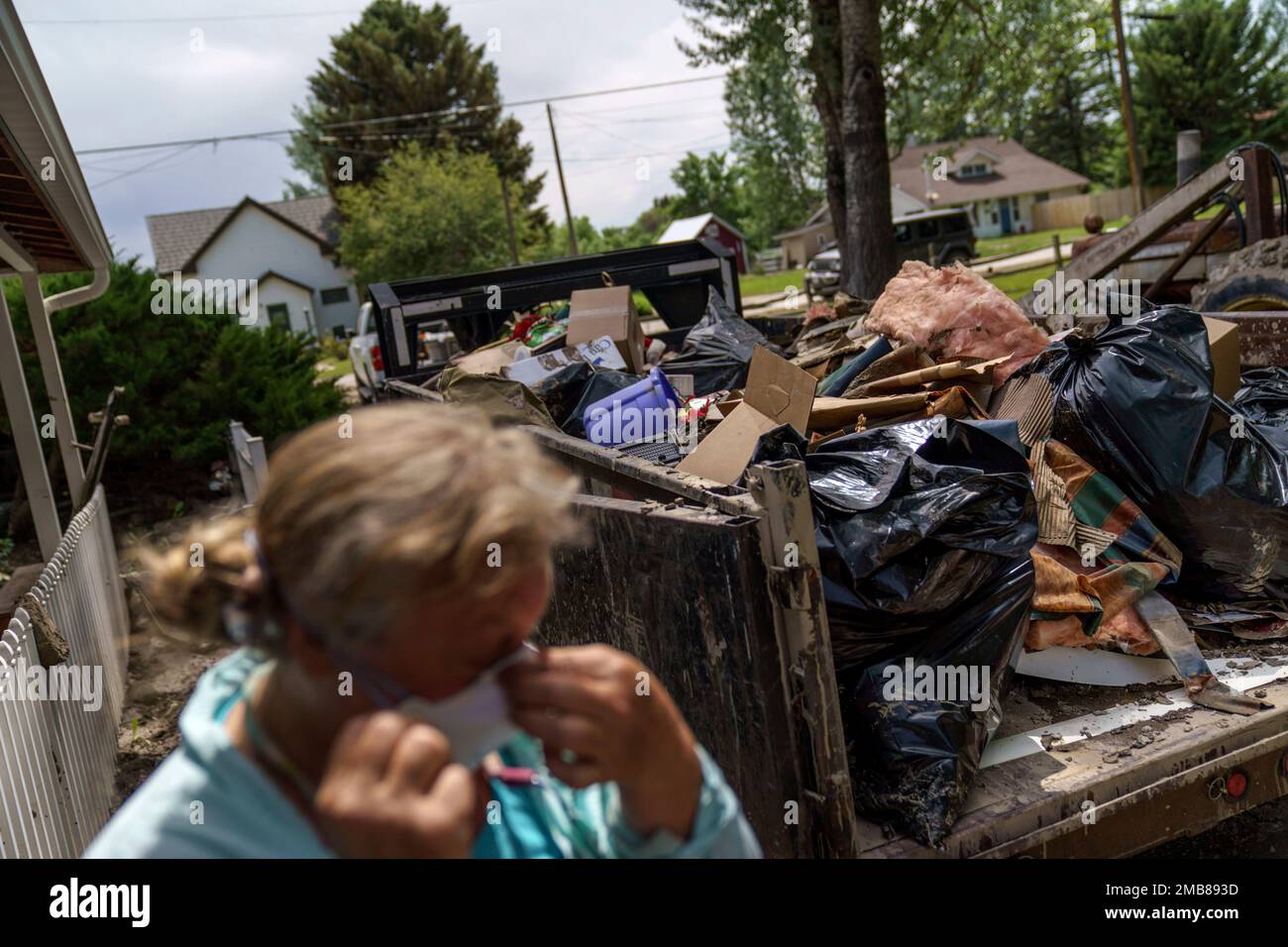 Melody Murter puts on a mask while helping to clean out a friend's home