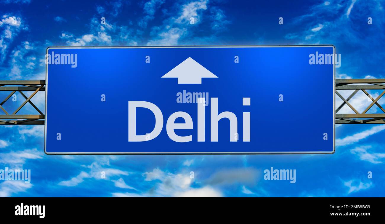 Road sign indicating direction to the city of Delhi. Stock Photo