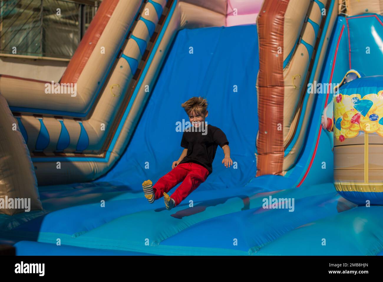 Kids having fun and sliding and jumping on outdoor playground. Kids Enjoying Stock Photo