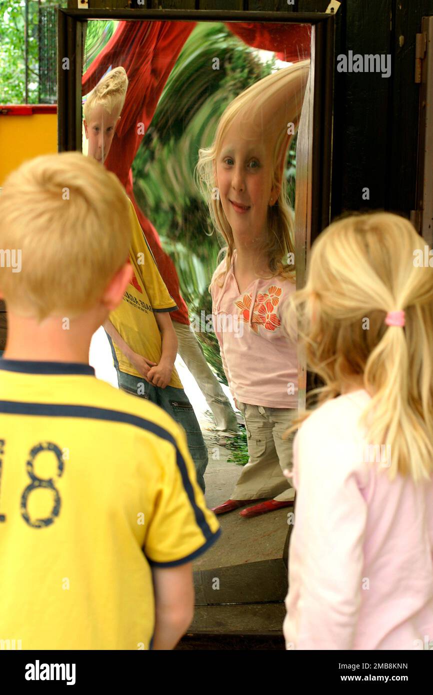 Netherlands, children look in a distorting mirror Stock Photo