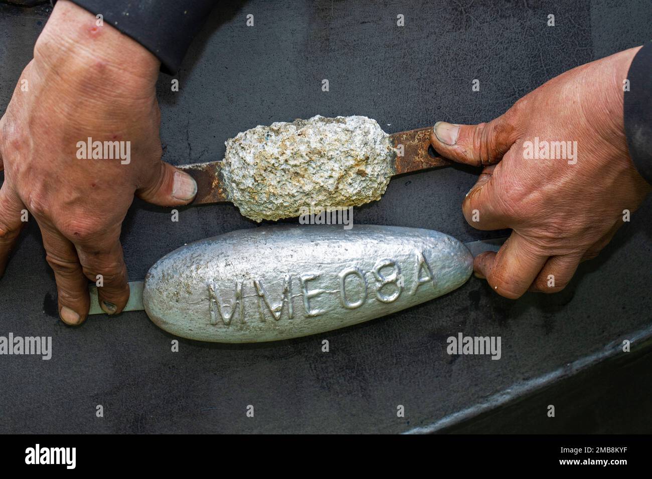 Anodes from zinc, new and eroded, attached to the hull of a boat as