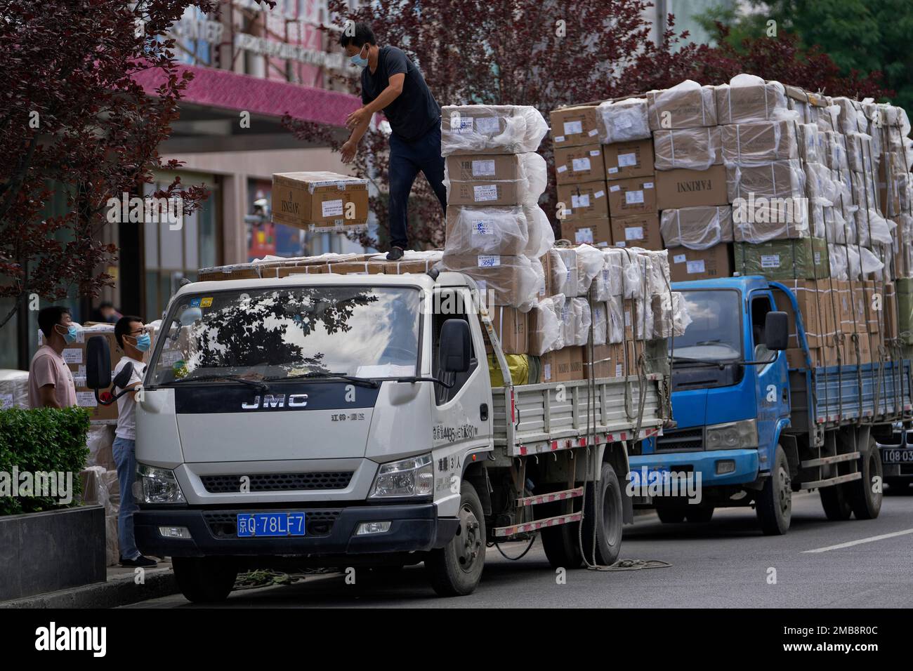 Workers load boxes of goods from a truck outside a wholesale clothing mall  in Beijing on Tuesday, June 14, 2022. China's factory output rebounded in  May, adding to a recovery from the