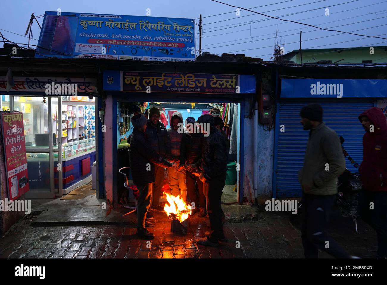 Shopkeepers warm themselves around a bonfire after heavy snowfall in  Joshimath, in the northern Indian state of Uttarakhand, Friday, Jan. 20,  2023. Joshimath is a temple town of around 25,000 people that