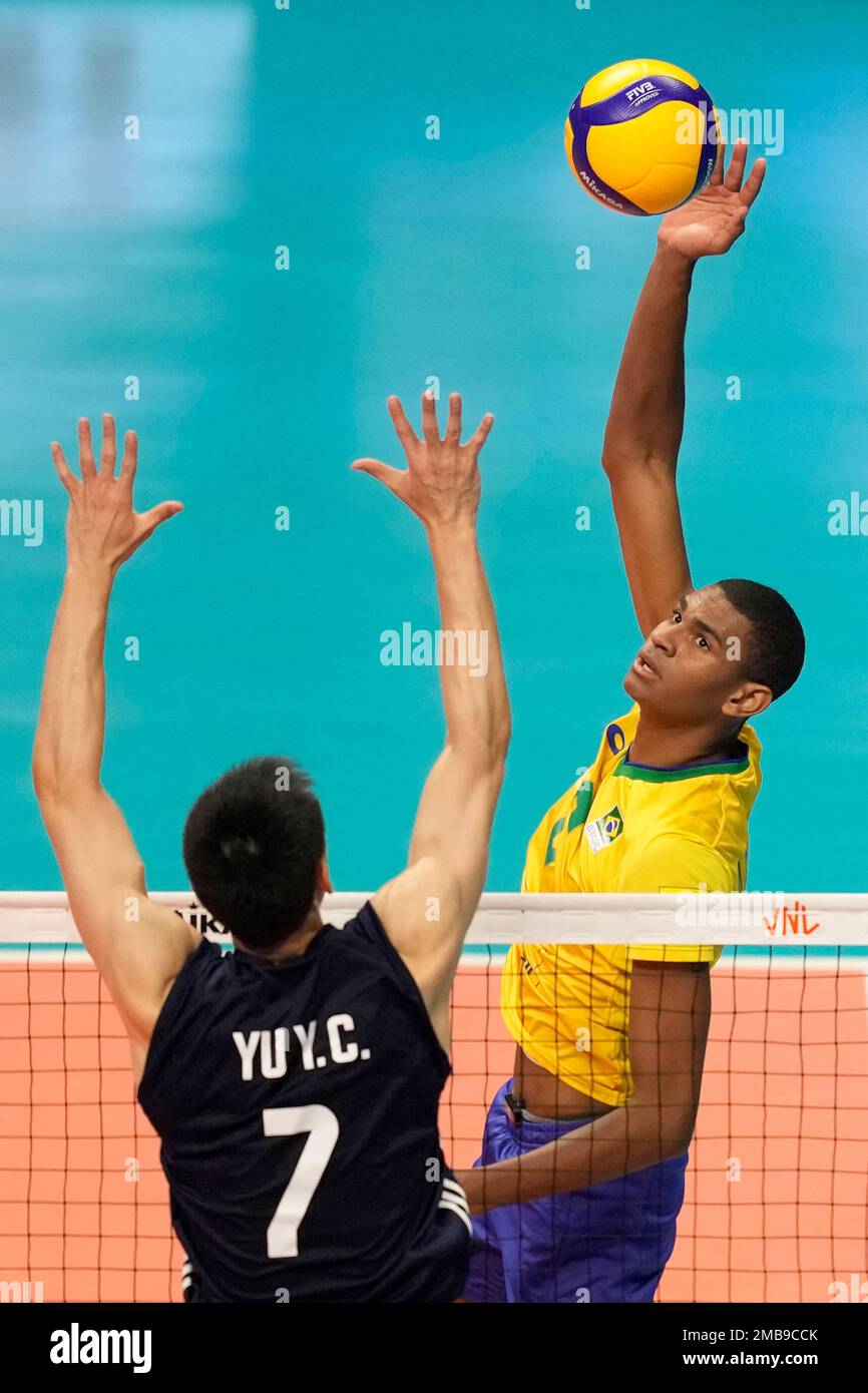Brazils Adriano spikes the ball against Yu Y.C of the China during a mens Nations League volleyball match in Brasilia, Brazil, Sunday, June 12, 2022