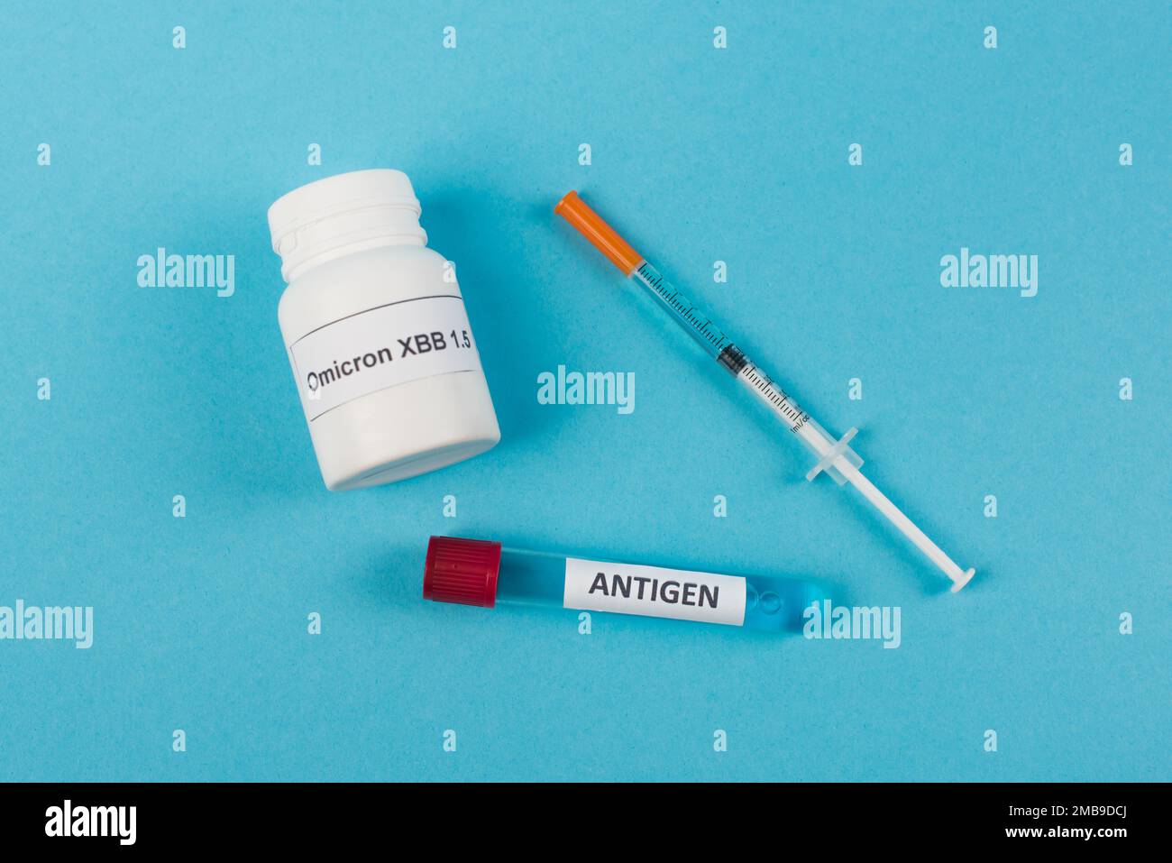 Top view of antigen near pills with omicron xbb lettering and syringe on blue background,stock