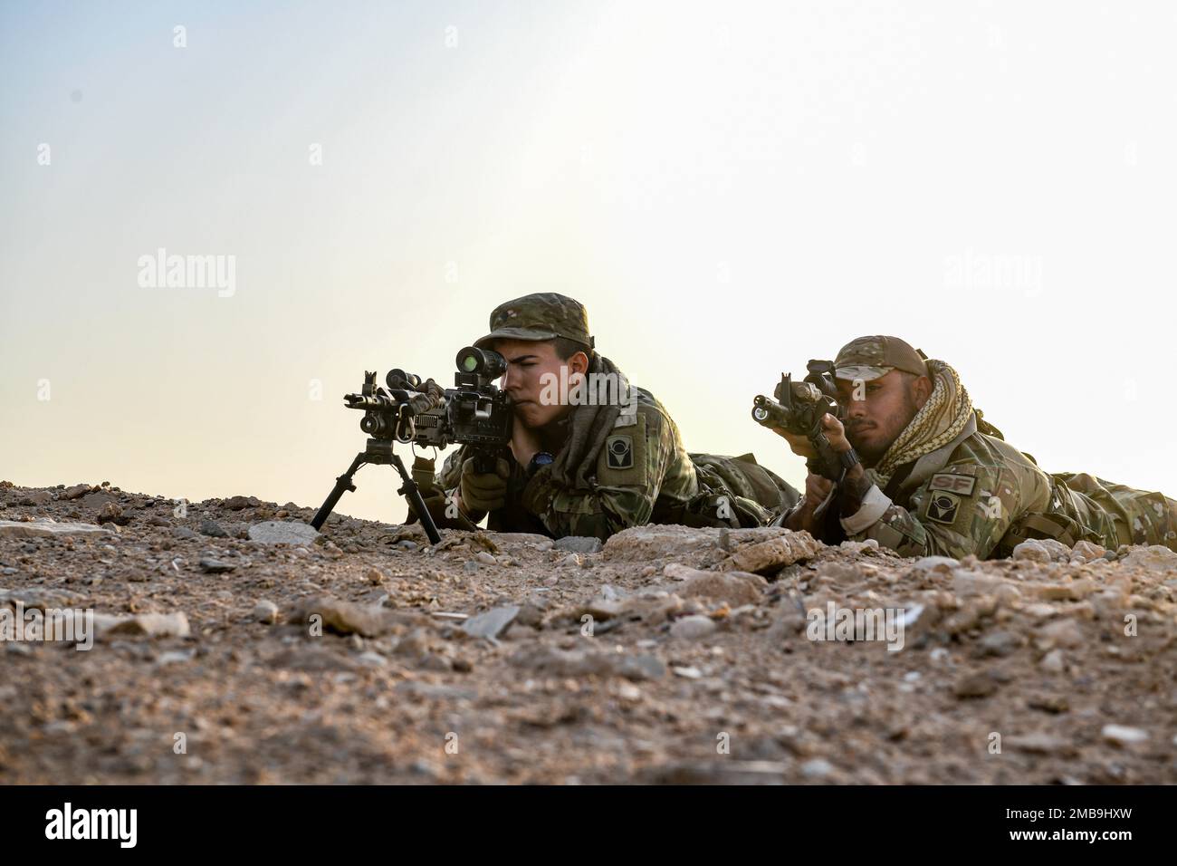 A U.S. Soldier with Task Force Hurricane from the 1st Battalion, 124th Infantry Regiment, and U.S. Air Force Staff Sgt. Alejandro Bachelier, a fireteam member assigned to the 378th Expeditionary Security Forces Squadron, hold a simulated ambush position, Al-Kharj, Kingdom of Saudi Arabia, June 13, 2022. Eight USAF Defenders were invited by the U.S. Army to attend Task Force Hurricane’s Platoon Immersion 3 alongside the Royal Saudi Land Force. The immersion allowed the 378th ESFS members a chance to develop as multi-capable Airmen by learning both Joint Force infantry tactics and Partner Nation Stock Photo