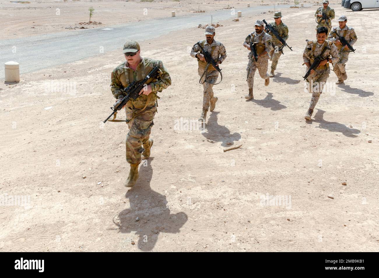 U.S. Air Force Senior Airman Zachary Fooks, assigned to the 378th Expeditionary Security Forces Squadron, leads Royal Saudi Land Force soldiers and U.S. Soldiers assigned to Task Force Hurricane in a rush to a mission objective, during a training exercise in Al-Kharj, Kingdom of Saudi Arabia, June 13, 2022. Eight USAF Defenders were invited by the U.S. Army to attend Task Force Hurricane’s platoon immersion course alongside the Royal Saudi Land Force. The immersion allowed the 378th ESFS members a chance to develop as multi-capable Airmen by learning both Joint Force infantry tactics and Partn Stock Photo