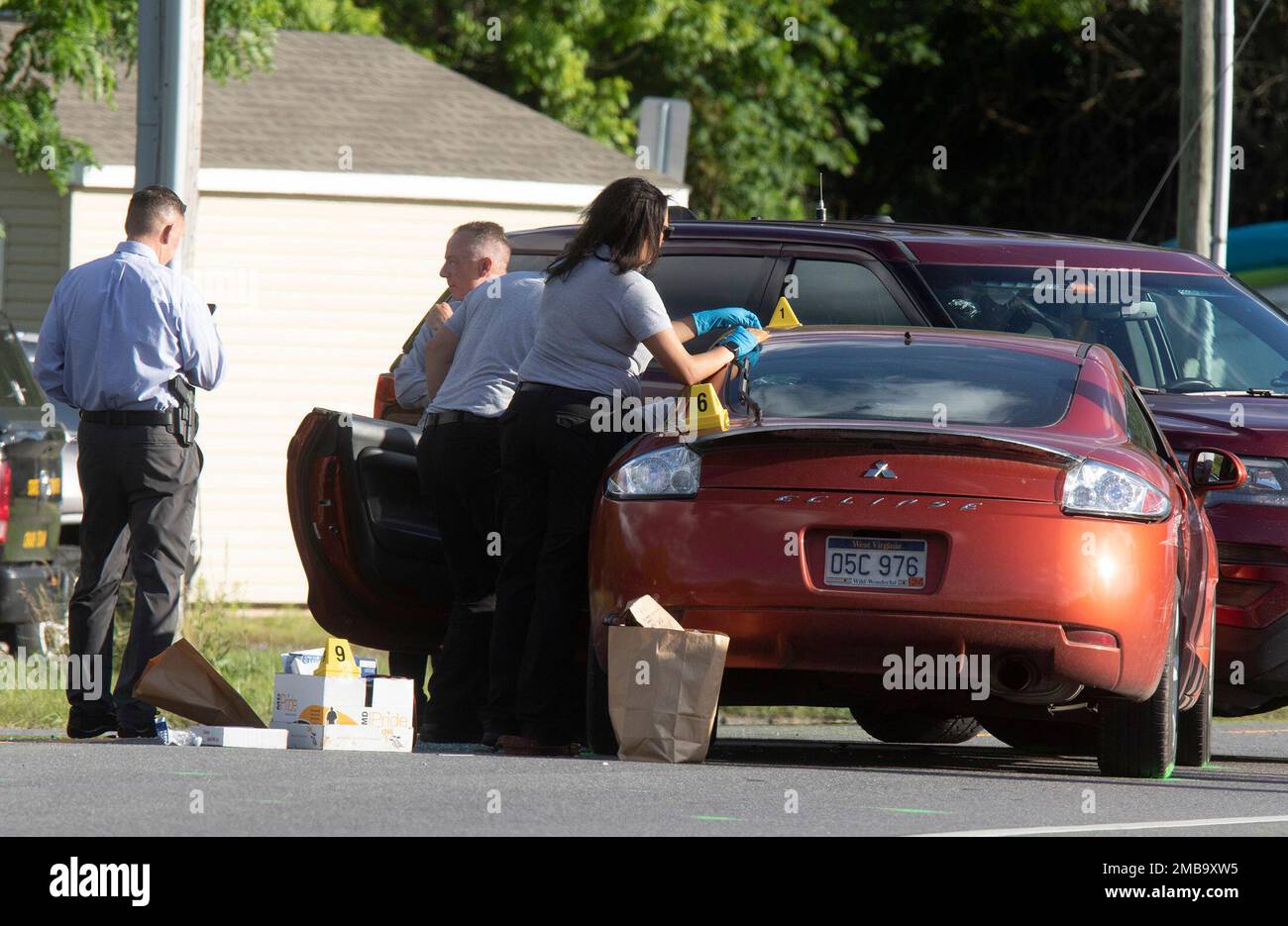 Law enforcement officials process evidence from one of two cars that