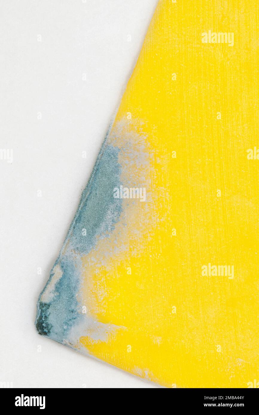 Cheddar cheese partial slice with mold growing on the corner. Flat lay