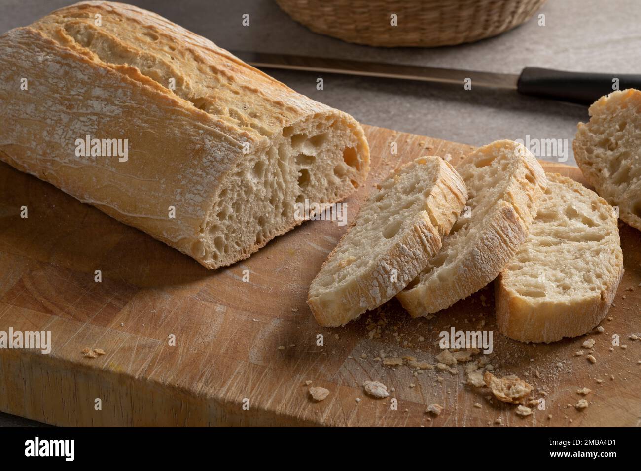 Traditional Italian fresh baked ciabatta bread and slices on a cutting board close up Stock Photo