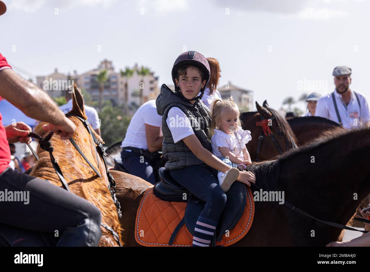 Costa Adeje, Tenerife, Canary Islands, 20 January 2023. Even young babies get on horseback at the fiesta of San Sebastian which returns for the first time since 2020 due to the covid pandemic restrictions. The annual fiesta in La Caleta on the Costa Adeje is enjoyed by locals and tourists who gather to see the many horses that come to bathe in the sea at the Playa Enramada beach. Credit: Phil Crean A/Alamy Live News Stock Photo