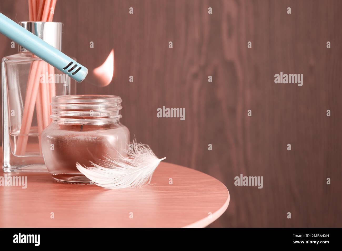 Aroma candle in the glass with scented sticks and lighter and feather