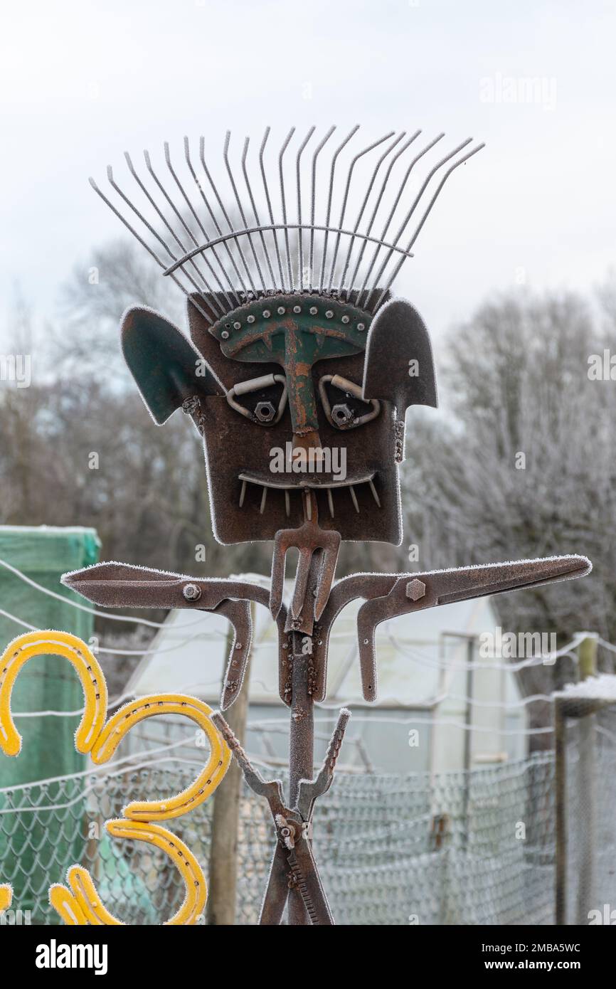 Quirky scarecrow on allotments constructed from metal gardening tools including a rake, England, UK Stock Photo