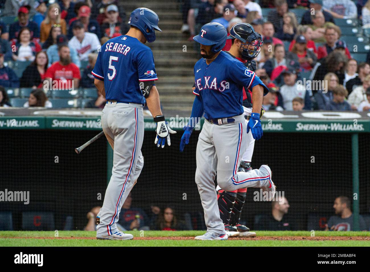 Texas Rangers' Corey Seager, left, greets Marcus Semien after his solo home  run off Cleveland Guardians starting pitcher Kirk McCarty during the third  inning of the second game of a baseball doubleheader